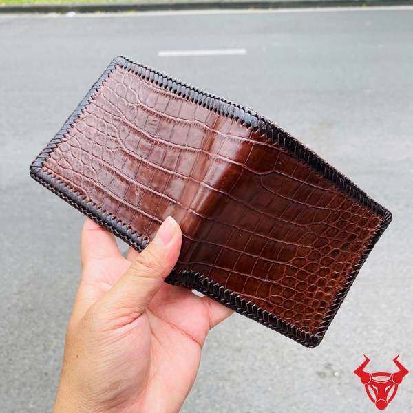 Ví da bụng cá sấu đan viền màu nâu đất nổi bật với thiết kế cao cấp và độ bền vượt trội.